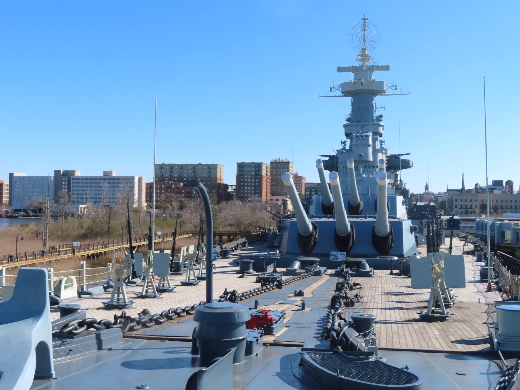 The Battleship USS North Carolina on the Cape Fear River with the Wilmington skyline behind it